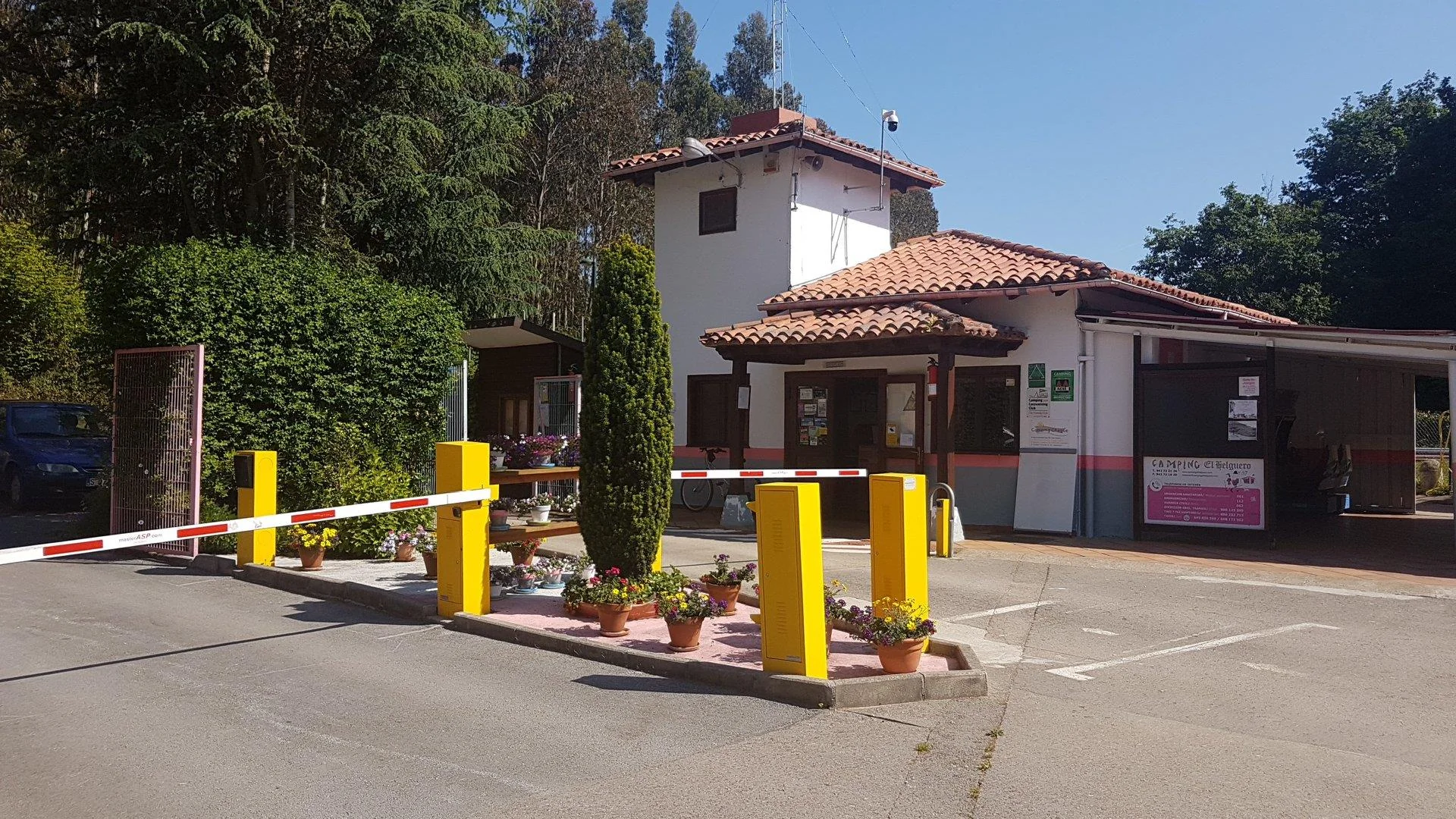 Entrada con barrera y edificio de recepción del Camping El Helguero, Ruiloba (Cantabria).